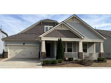 Charming home with a covered porch, attached garage, and manicured landscaping at 1205 Steinbeck Dr, Durham, NC 27703
