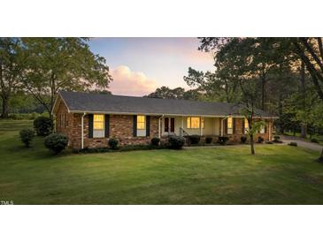 Charming brick ranch home with a lush front lawn and well-maintained landscaping offers great curb appeal at 129 Castle Dr, Smithfield, NC 27577