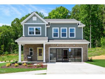 Charming two-story home featuring a brick facade, welcoming front porch, and well-maintained landscaping at 134 Beacon Dr, Pittsboro, NC 27312