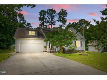 Charming home featuring a spacious driveway, two-car garage, manicured lawn, and inviting curb appeal at 153 Hickory Nut Dr, Smithfield, NC 27577