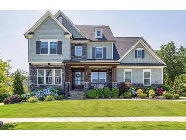 Charming two-story home with a landscaped front yard and inviting front porch at 205 Silent Cove Ln, Holly Springs, NC 27540