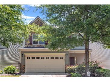 Charming two-story home featuring a stone accent facade, attached garage, and landscaped yard at 211 Westgrove Ct, Durham, NC 27703