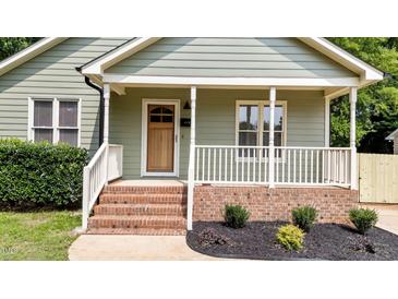 Charming front porch with brick steps, and a natural wood front door at 413 Top Greene Ln, Raleigh, NC 27601