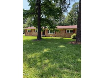 Charming brick ranch-style home with a lush green lawn and mature shade trees at 4618 Blanchard Rd, Durham, NC 27713