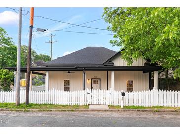 Charming renovated home with a fresh white exterior, black trim, a covered porch, and a picket fence at 516 Ottawa Ave, Durham, NC 27701