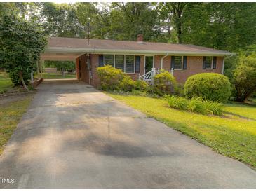 Charming brick home with well-maintained landscaping and covered parking at 5504 Balsam Pl, Raleigh, NC 27603