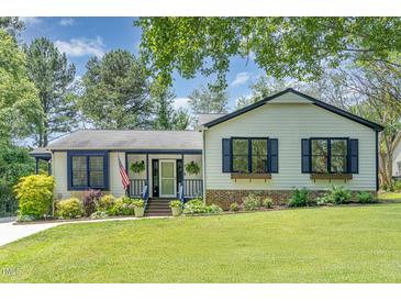Charming single-story home featuring a well-manicured lawn and inviting front porch at 5617 Groomsbridge Ct, Raleigh, NC 27612