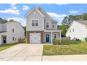 Charming two-story home with light grey siding, brick accents, and a well-manicured lawn at 6512 Bunker Hill Dr, Raleigh, NC 27610