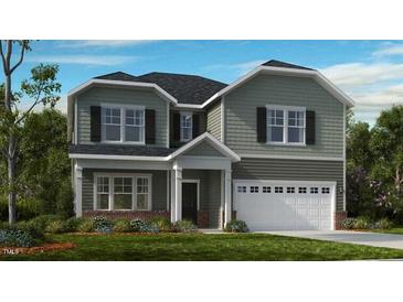 Charming two-story home with a two-car garage, a covered entry, and a well-maintained lawn at 668 Morning Glade St, Wake Forest, NC 27587