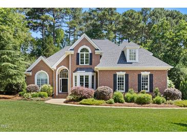 Charming brick home with manicured lawn, mature trees, and welcoming curb appeal at 103 Saint Brides Ct, Cary, NC 27518