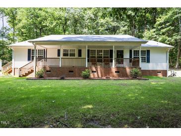 Charming single-story home with brick foundation, cozy front porch, lush lawn, and mature trees at 117 Lema Dr, Garner, NC 27529