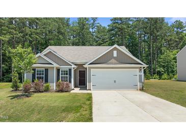 Charming single-story home with a well-manicured lawn, two-car garage, and welcoming front entrance at 145 Bounding Ln, Youngsville, NC 27596