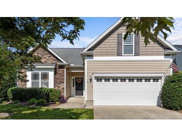 Charming home featuring a stone facade, neutral siding, a two-car garage, and manicured landscaping at 2117 Crockett Ridge Rd, Fuquay Varina, NC 27526