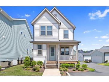 Charming two-story home with a covered front porch and beautifully landscaped front yard at 212 Aubey Ln, Wake Forest, NC 27587