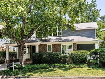 Charming brick home with a large tree in front and a covered carport at 2212 Oxford Hills Dr, Raleigh, NC 27608