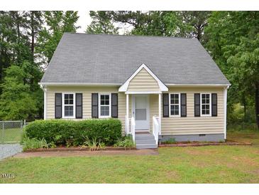 Charming tan home with a cozy front porch, dark shutters and well-maintained landscaping at 2708 Sundial Cir, Durham, NC 27704