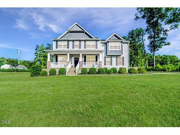 Charming two-story home with a large front yard and inviting covered porch at 2802 Bingham Dr, Mebane, NC 27302