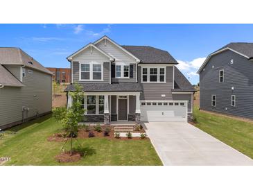 Charming two-story home featuring a two-car garage, manicured lawn, and welcoming covered porch at 3500 Bailey Lake Dr, Fuquay Varina, NC 27526