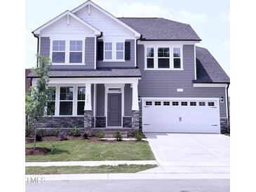 Charming two-story home features a modern gray exterior, well-manicured lawn, and attached two-car garage at 3500 Bailey Lake Dr, Fuquay Varina, NC 27526