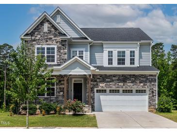 Charming two-story home showcasing a stone and siding exterior, lush landscaping, and a welcoming two-car garage at 359 Abbot Pl, Chapel Hill, NC 27516