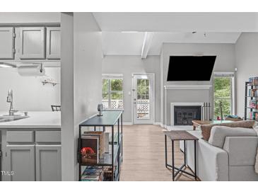 Bright living room features hardwood floors, a modern fireplace, and an abundance of natural light at 405 Gooseneck Dr # B6, Cary, NC 27513