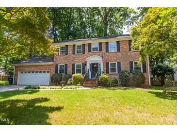 Charming two-story brick home with attached garage and a lush, landscaped front yard at 4200 Marvin Pl, Raleigh, NC 27609