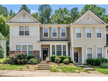 Two-story townhome with neutral siding, black front door, and well-maintained landscaping with mature flowering bushes at 4353 Sugarbend Way, Raleigh, NC 27606