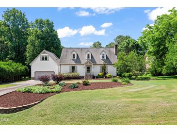 Charming home featuring a landscaped front yard, dormer windows, and attached garage at 4720 Cedarfield Dr, Raleigh, NC 27606