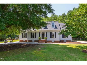 Traditional-style home featuring a well-manicured lawn, mature trees, dormers, and charming curb appeal at 5413 Lower Creek Ct, Apex, NC 27539