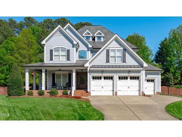 Charming two-story home featuring a three-car garage, inviting front porch, and well-maintained landscaping at 6004 Brass Tack Ct, Fuquay Varina, NC 27526