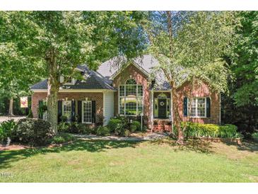 Charming brick home featuring a well-manicured lawn and lush landscaping at 65 Georgetown Woods Dr, Youngsville, NC 27596