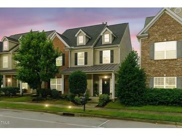 Charming two-story home featuring dormer windows and a welcoming covered front porch at dusk at 732 Keystone Park Dr, Morrisville, NC 27560