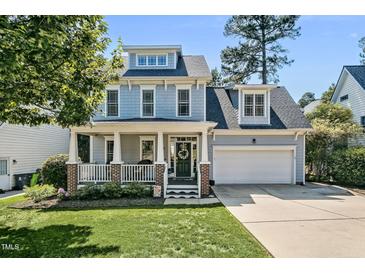 Charming two-story home with a welcoming front porch and well-maintained lawn and an attached two-car garage at 908 Town Side Dr, Apex, NC 27502