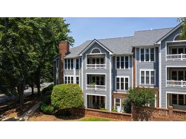 Beautiful three-story condo building featuring gray siding, white trim, and brick accent wall at 911 Washington St # 304, Raleigh, NC 27605