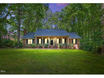 Charming brick home featuring a covered porch with stately columns and manicured landscaping at 9257 Sauls Rd, Raleigh, NC 27603