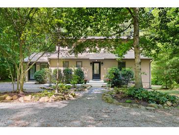 Charming home featuring a gravel driveway and beautifully landscaped front yard at 9507 Sertoma Rd, Chapel Hill, NC 27516