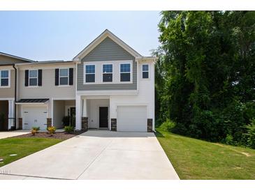 Charming townhome featuring a one-car garage and inviting curb appeal with green lawn at 97 Begonia St, Angier, NC 27501