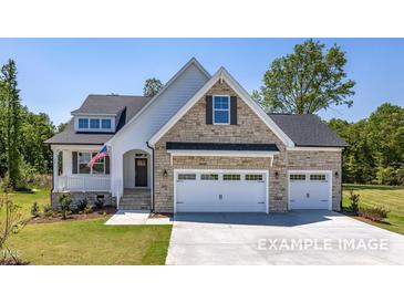 Beautiful stone and siding exterior with a three-car garage and well-manicured lawn at 98 Priming Way, Angier, NC 27501