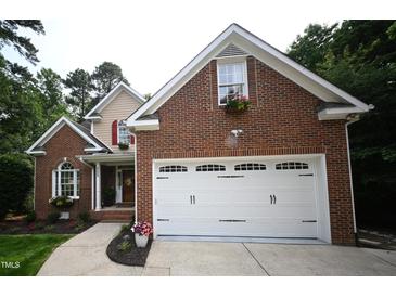 Charming brick home featuring a two-car garage and flower boxes under the windows at 111 Ferncroft Ct, Cary, NC 27519
