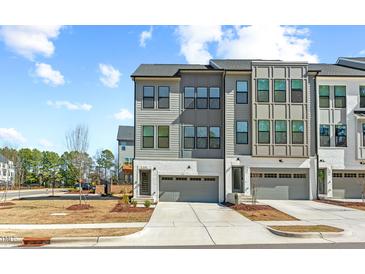 Modern townhome featuring a two-car garage, neutral-toned siding, and an inviting entryway in a residential neighborhood at 1203 Corkery Ridge Ct, Cary, NC 27519