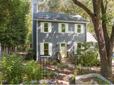 Charming two-story home with a landscaped front yard and garden, featuring white trim and a welcoming entrance at 1605 Valley Run, Durham, NC 27707