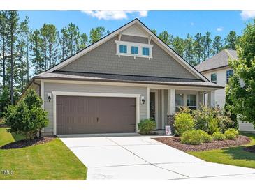 Charming home featuring a two-car garage, well-maintained lawn, and beautifully landscaped front yard at 1724 Capstone Dr, Durham, NC 27713
