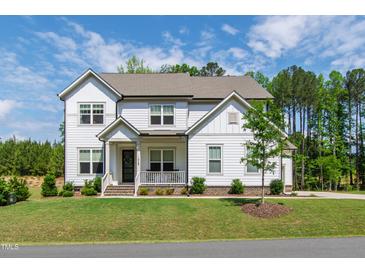 Charming two-story home with a manicured lawn and a welcoming front porch, perfect for enjoying the outdoors at 1928 Vandiver Way, Apex, NC 27523