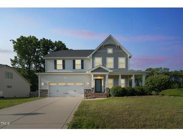 Charming two-story home with a two-car garage, landscaped yard, and covered front porch at 20 Sugarpine Trl, Clayton, NC 27520