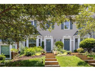 Charming townhomes featuring beautiful landscaping, front steps and gray siding at 318 Silverberry Ct, Cary, NC 27513
