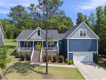 Charming blue two-story home with welcoming front porch and landscaped front yard at 374 Heart Pine Dr, Wendell, NC 27591