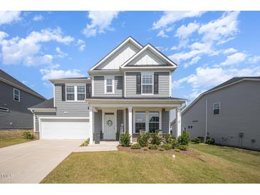 Beautiful two-story home with gray siding, white trim, and a well-manicured lawn at 645 Longstanton Ave, Zebulon, NC 27597