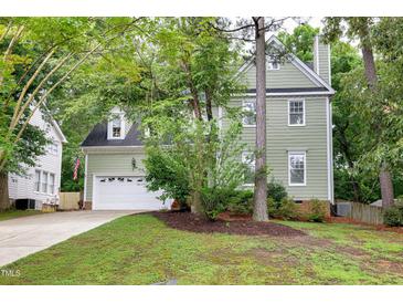 Charming two-story home with a lush green lawn and attached two car garage at 709 Bonhurst Dr, Holly Springs, NC 27540
