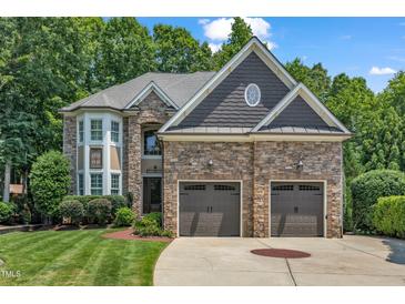 Beautiful stone home with a two-car garage and manicured lawn at 104 Bellagio Dr, Apex, NC 27539