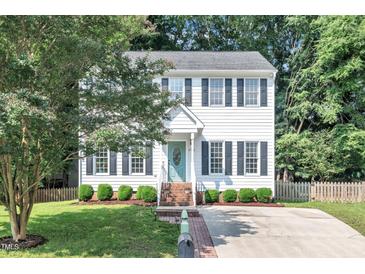 Charming two-story home with a well-manicured lawn and a welcoming front entrance with a teal-colored front door at 1905 Indianwood Ct, Raleigh, NC 27604